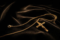 Colgante de cruz y cadena sobre terciopelo negro