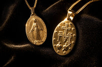 Anverso y reverso de la medalla de la Virgen Milagrosa sobre terciopelo negro